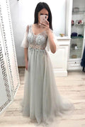 Une robe de bal grise à manches courtes et col en V avec une ligne A et une longue jupe en tulle  PM202