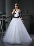 Robe de mariée longue en tulle sans manches à bretelles perlées et jupon boule