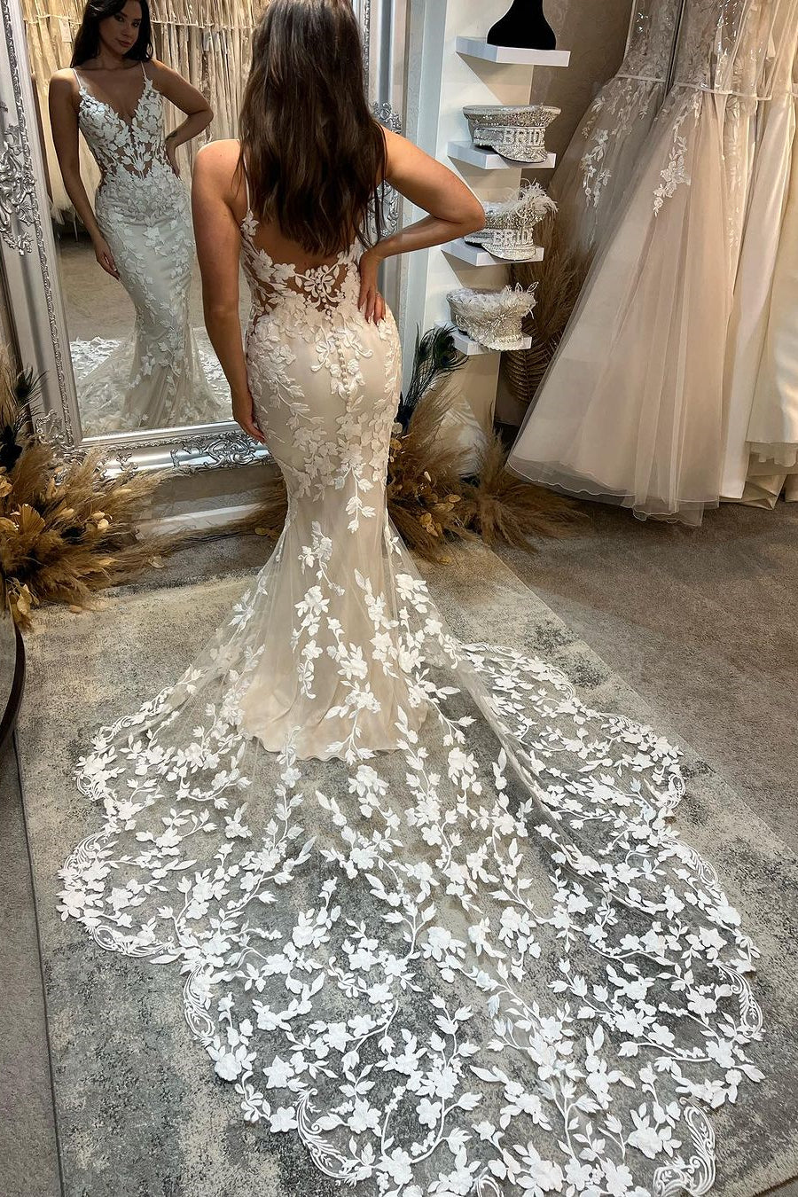 Robe de mariée longue et charmante à dos nu, décolleté en V et traîne, avec applications et bretelles spaghetti style sirène