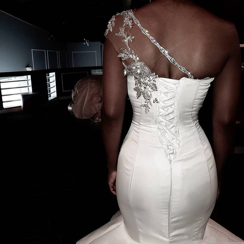 Abito da sposa sirena con spalla scoperta e strascico a balze