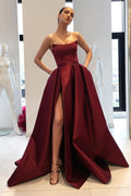Vestido de fiesta strapless color burdeos en corte sirena y satén con abertura lateral