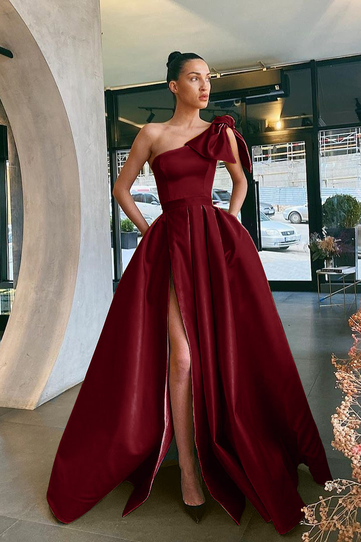 Vestidos de festa compridos em cetim com corte A e um ombro só, cor vinho, com racha e bolsos
